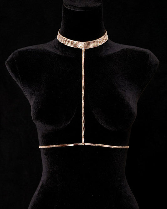 Joia Camila dourada: body chain com choker de strass, corrente central e cintura, em busto preto sobre fundo preto