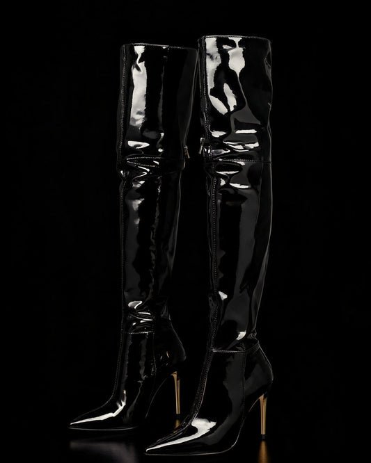 Bota vinil preta over the knee com bico fino e salto agulha dourado, sobre fundo preto