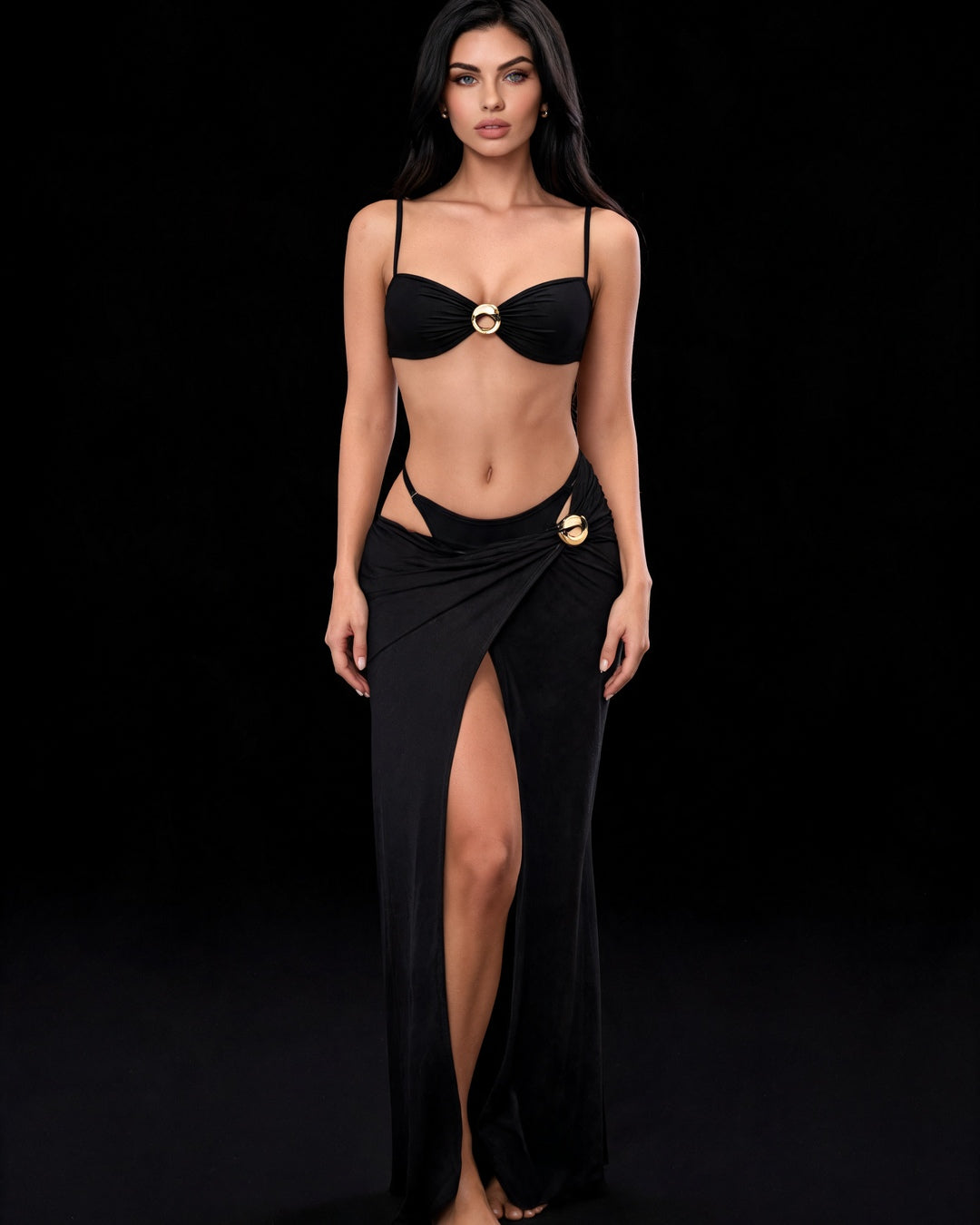 Conjunto Oceane preto: top, calcinha e saia longa com fenda e argolas douradas, em modelo de frente sobre fundo preto