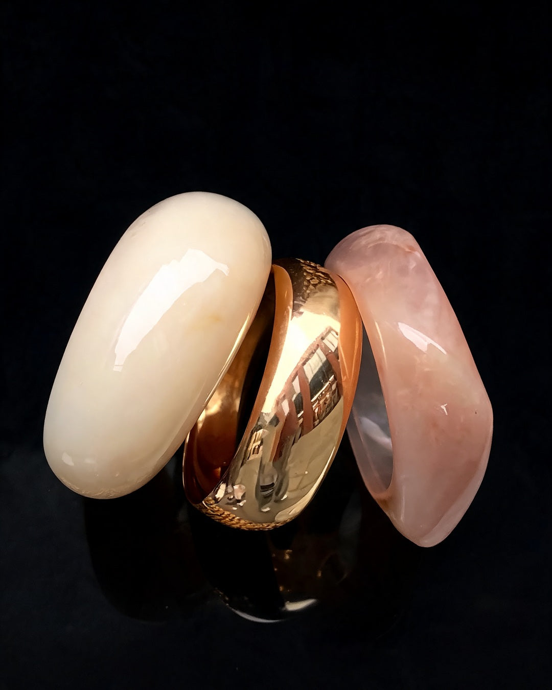 Bracelete Deusa do Mar: trio de pulseiras em resina creme, dourada e rosé, sobre fundo preto