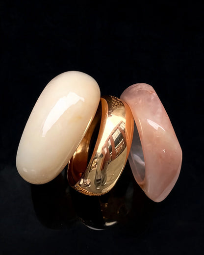 Bracelete Deusa do Mar: trio de pulseiras em resina creme, dourada e rosé, sobre fundo preto