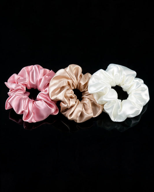 Scrunchies Ninfa das Águas em cetim rosa, champanhe e marfim, sobre fundo preto